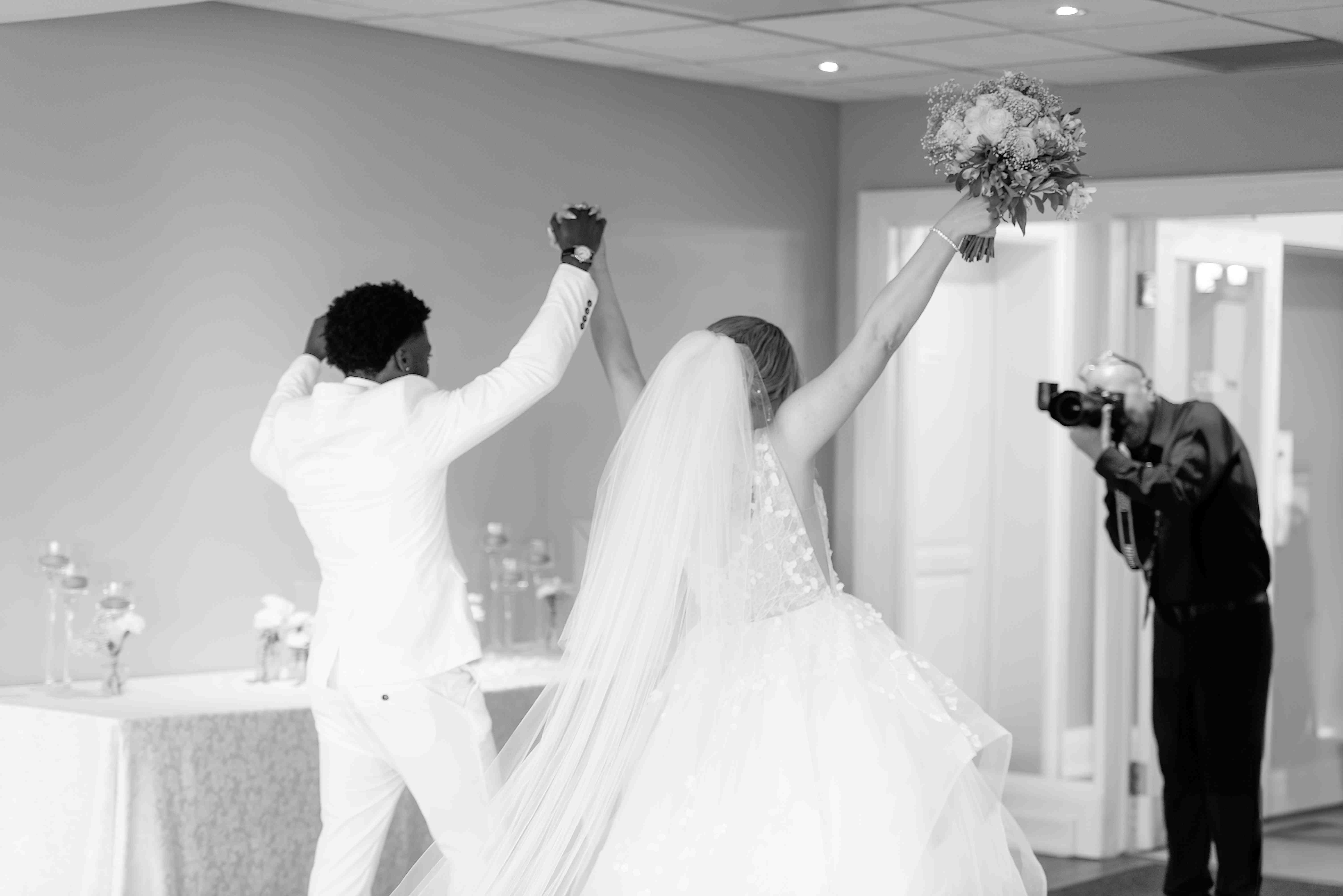 Joyful bride and groom making a grand entrance at their wedding reception in Hamilton, Ontario — captured candidly