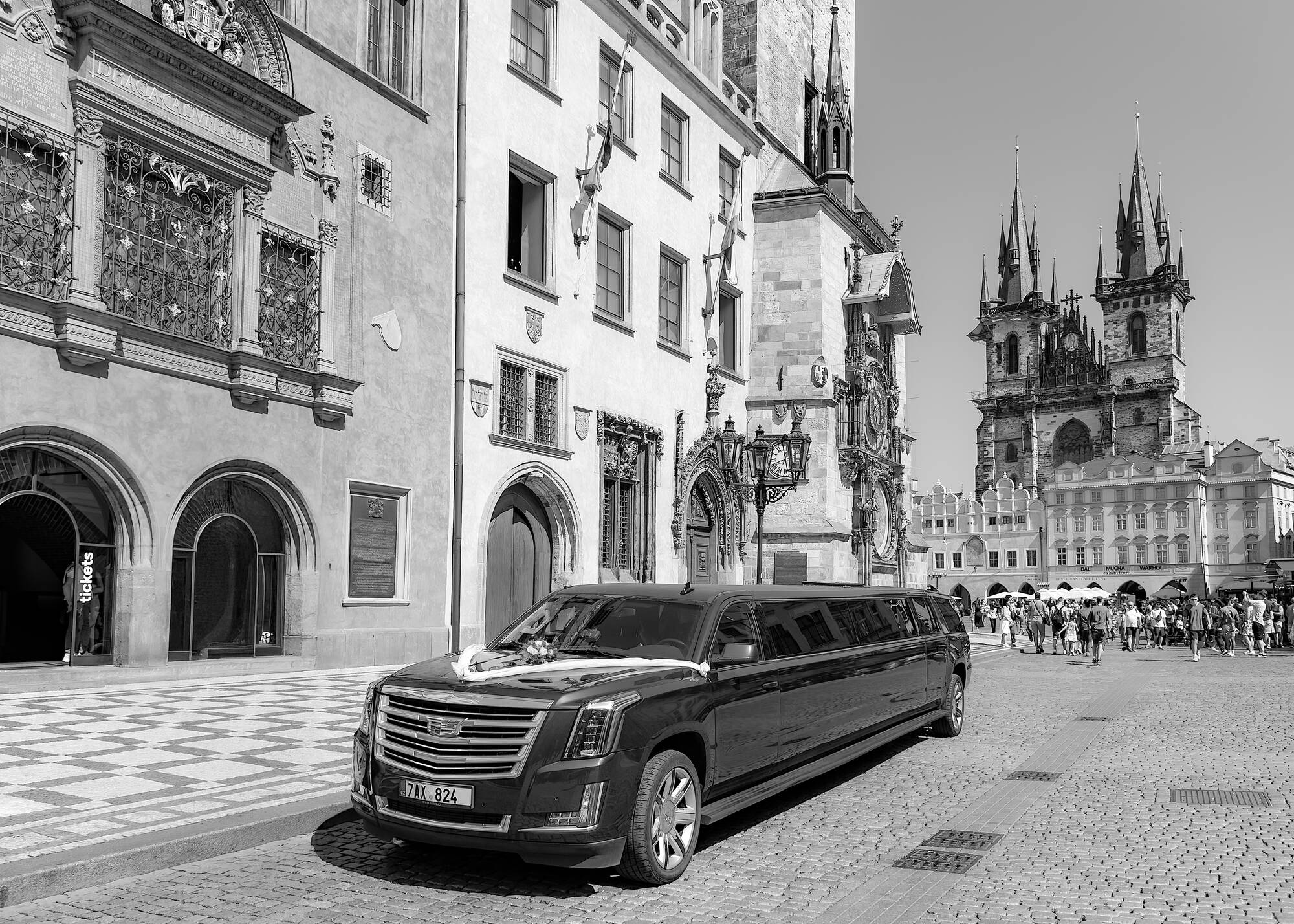 Black-and-white destination travel photograph of a wedding limousine in Prague Old Town Square — destination photography by NN Popa Photography